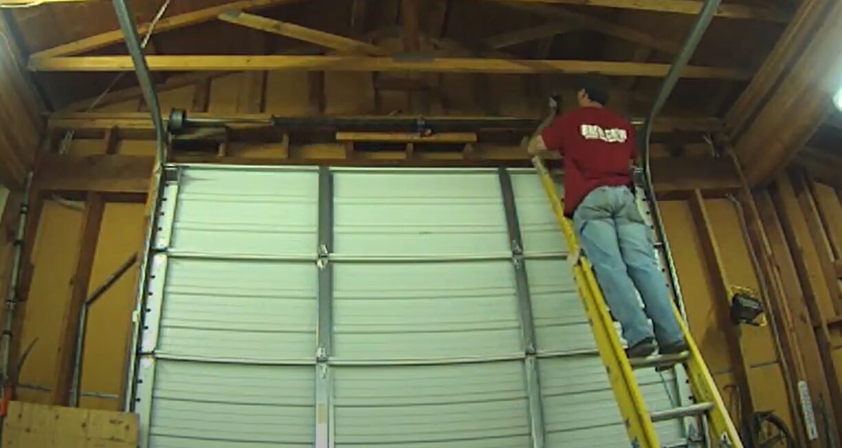 Technician repairing a garage door spring - Element Garage Doors Repair LLC